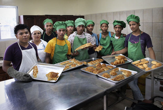 Jóvenes que participan en el taller de panadería muestran el pan que elaboran en las instalaciones del Centro Juventud. Foto Roberto Valencia.